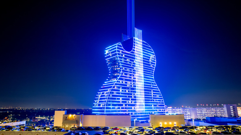 Guitar-shaped hotel illuminated in blue neon lights at night