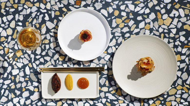 Multiple dishes featured in Itamae AO's Tasting Menu on a terrazzo counter