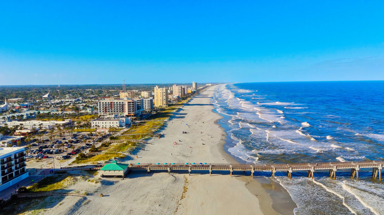 A pier extending over sand and water in Jacksonville