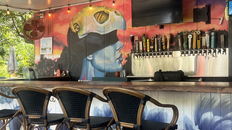 Colorful mural behind bar with multiple beer taps at The Lagoon on Grassy Key in Marathon, Florida
