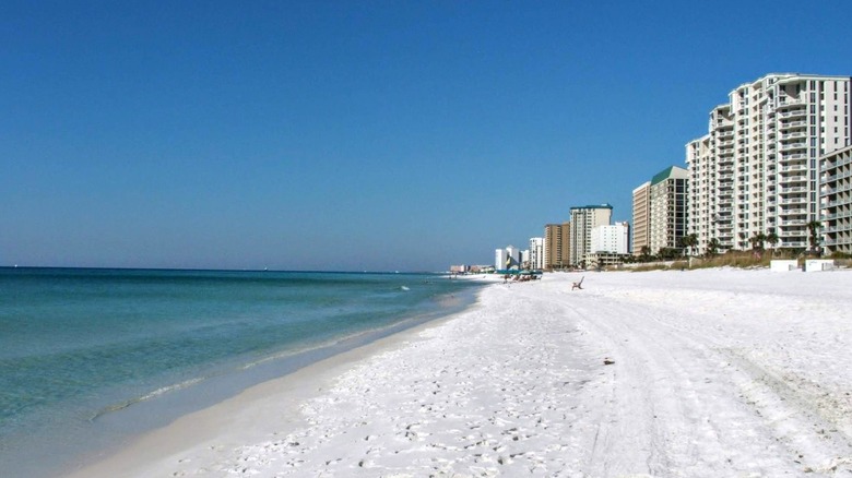 white sand beach with hotels, turquoise water, blue sky