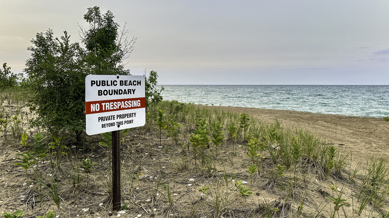 A no tresspassing sign on the dunes of a beach