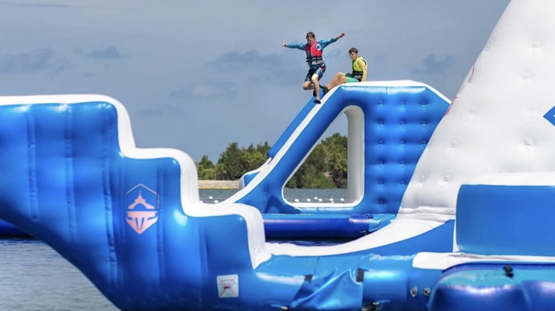Kids jump off giant inflatables at the Aqua Park inside Sun West Park