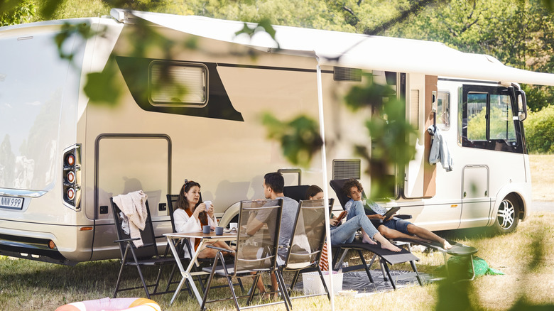 A family hanging out in front of their RV