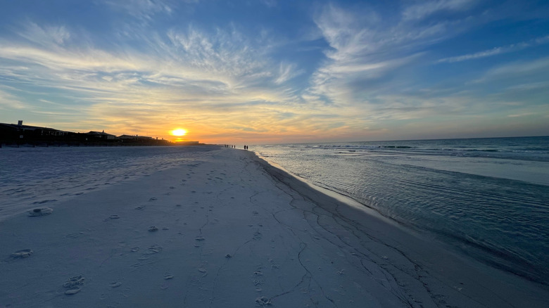 Miramar Beach with white sand stretching towards sunset