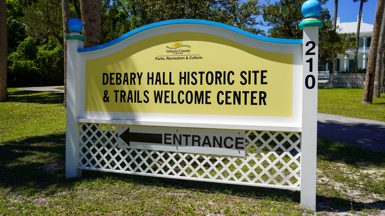 sign for Debary Hall with house in the background