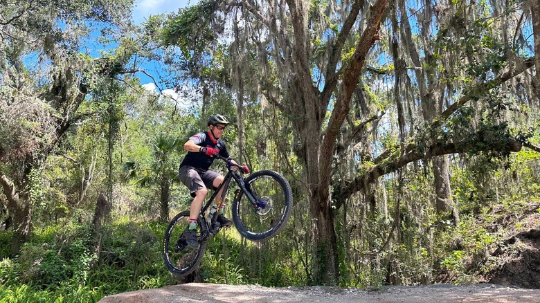 A guy getting air on a mountain bike trail in Alafia River State Park