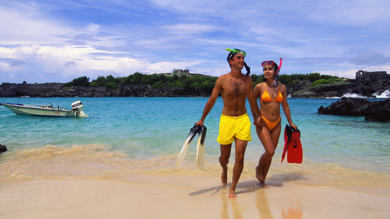 couple walks on Bermuda beach after snorkeling