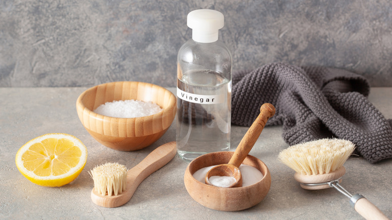 Small bottle of vinegar with cleaning supplies