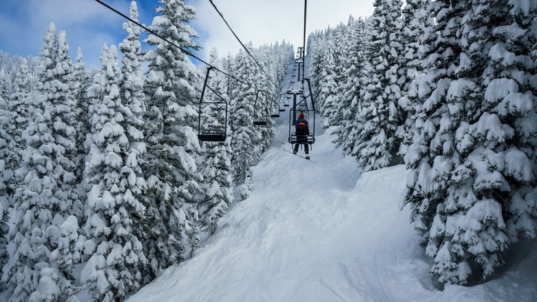 a snowboarder riding a chairlift at Steamboat Springs