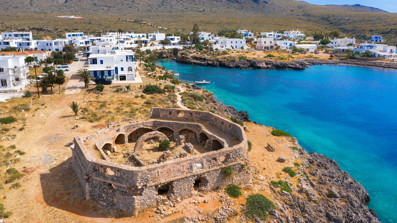 an aerial photo of the castle of avlemonas and bright blue sea water