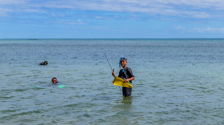 Local children fishing on the shores of Nacula in Fiji