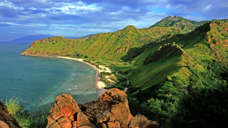 One of the beaches of Dili, with the characteristic green mountains of Timor-Leste behind the beach