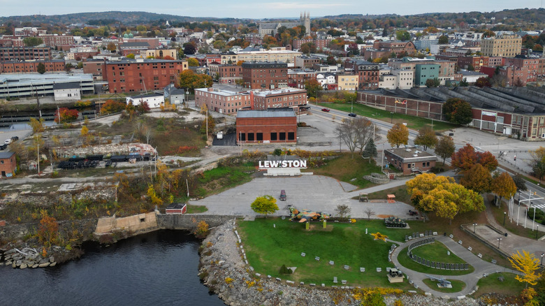 Aerial view of Lewiston, Maine's downtown buildings and parks with forested hills in the background