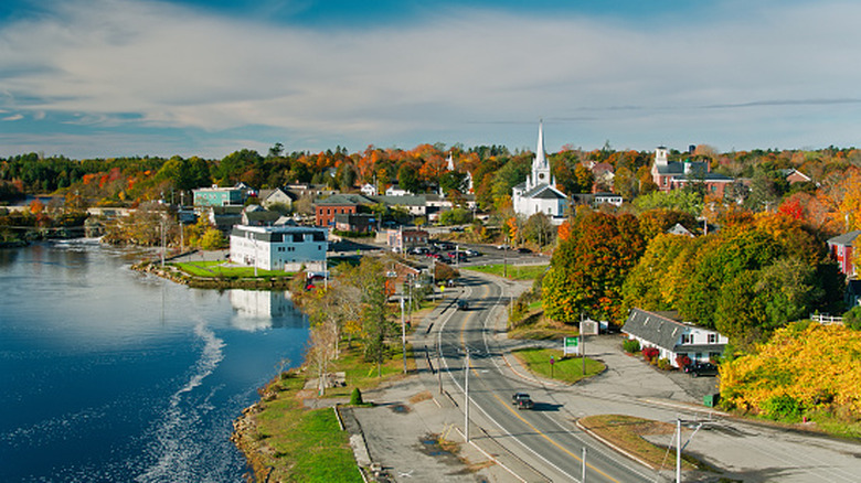 An aerial view of a road leading into Skowhegan, Maine on a sunny autumn day