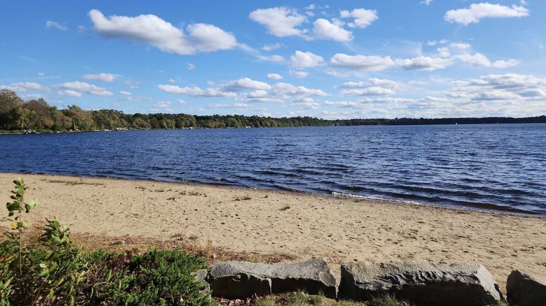 A view of lake Massapoag from Memorial Park Beach on a bright day in Sharon, MA