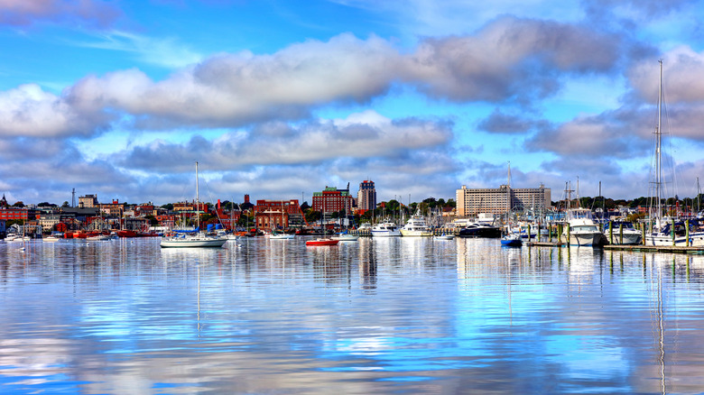 View of New Bedford, Massachusetts from the water, with boats and the skyline in the background, blue sky and white clouds above