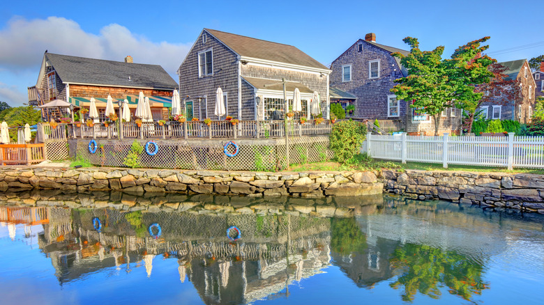 Historic cottages reflected in calm water on a sunny day
