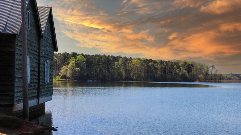 A wooden property on Lake Horton overlooks a leafy bank opposite at sunset in Fayette County, Georgia