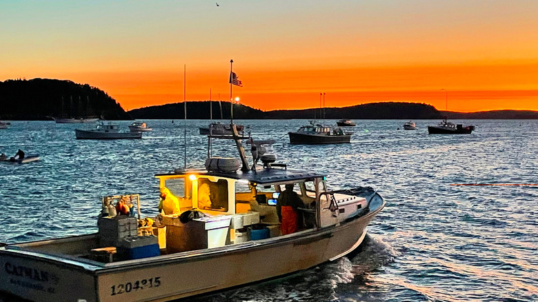 A lobster boat heads out to sea off the coast of Maine at sunrise