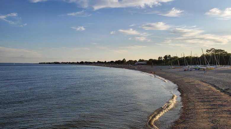 The calm waters at Jennings Beach at sunset, with boats and people on the shore