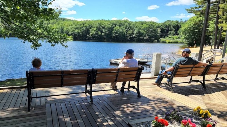 Elderly people sitting on benches overlooking the water at Dunn State Park in Gardner