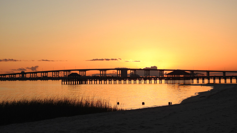 A bridge over open water and salt marsh at sunset in Ocean Springs, Mississippi