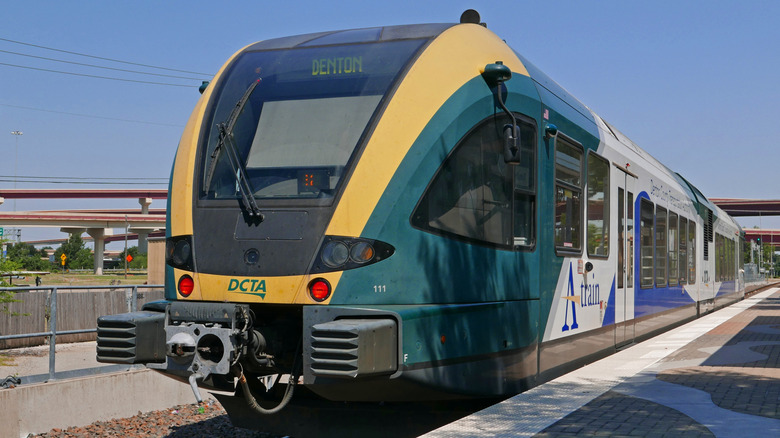 A light rail engine parks at a station near Carrollton, Texas on a sunny day