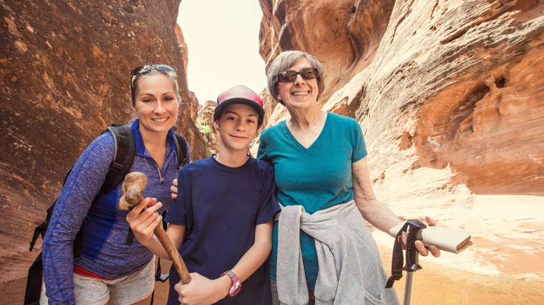 Three generations of a family hiking in a Utah slot canyon