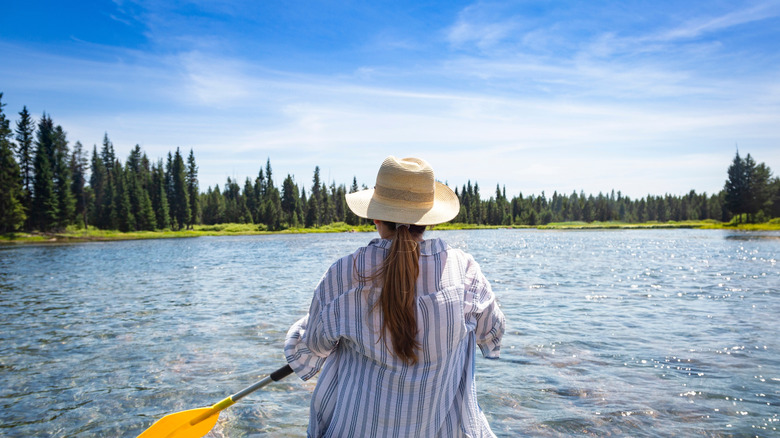 A woman seen from behind, rafting solo down the Snake River in Idaho