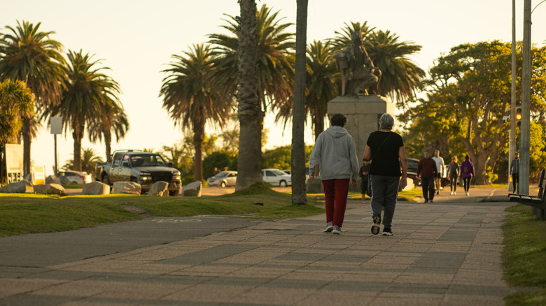 Two elderly people walking on a boardwalk in Montevideo, Uruguay