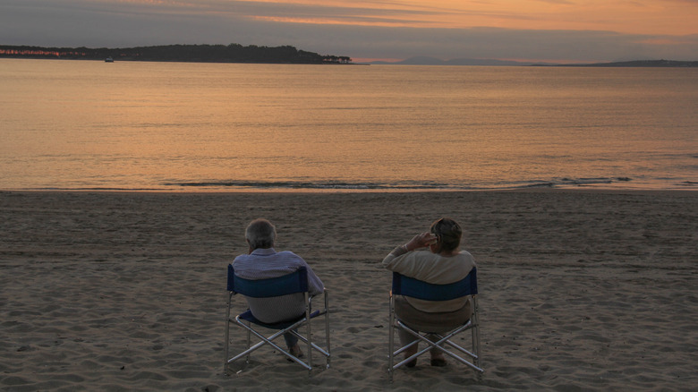 An older couple watching the sunset by the shore of Punta del Este, Uruguay