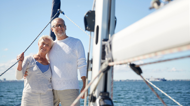 A senior couple standing on a sailboat