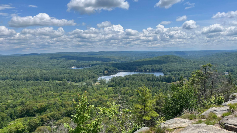 View of lush forests, a cloudy sky, and a reflective lake at Tully Mountain near Orange, Massachusetts