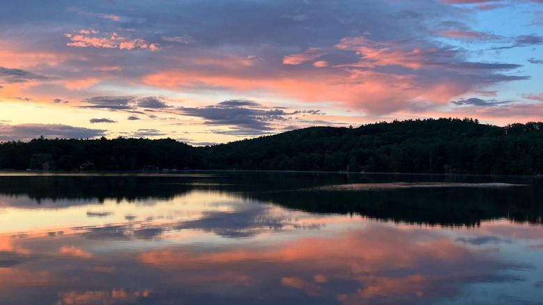 Lake Mattawa is mirror-still, reflecting a variegated cloudy sky with dark hills in the background