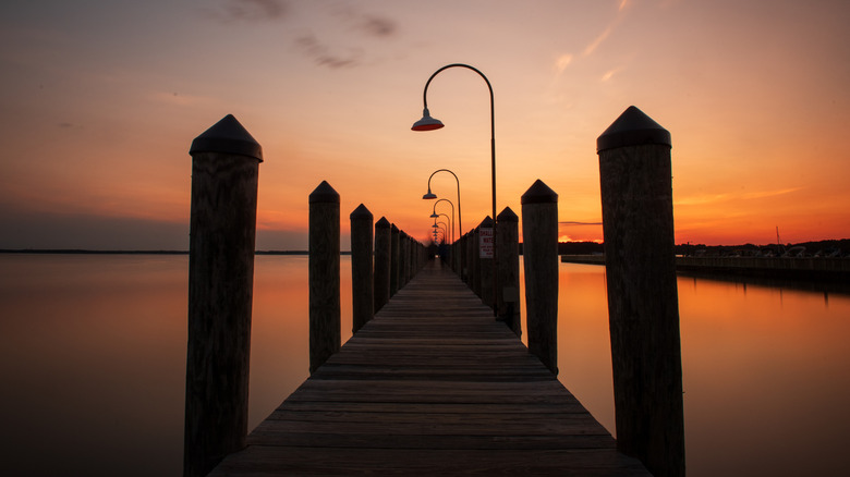 A deep orange and red Delaware sunset over a dock in Rehoboth Bay at the Lighthouse, Dewey Beach