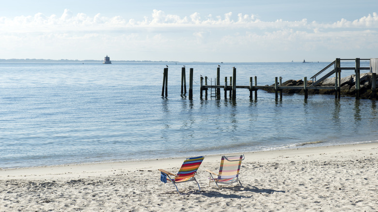 Chairs on beach with a lighthouse in background in New London, Connecticut
