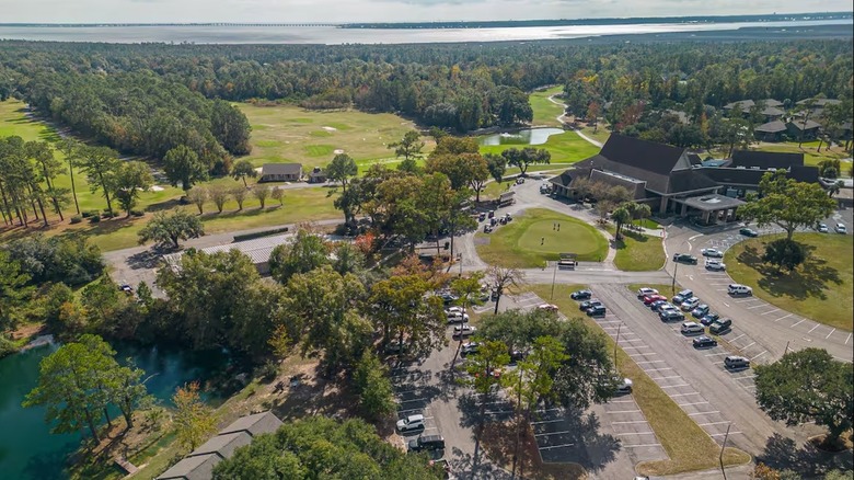 An arial view of the golf courses, lake, and clubhouse at Diamondhead.