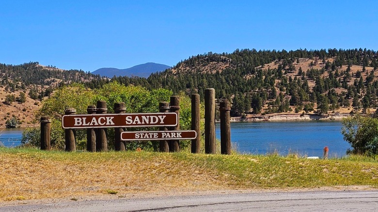 Black Sandy State Park sign with lake and trees in background