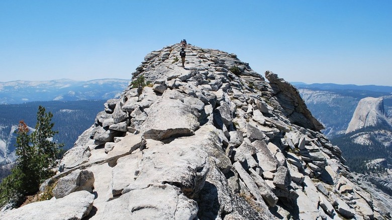 A hiker crossing the knife-edge ridgeline to Yosemite's Clouds Rest