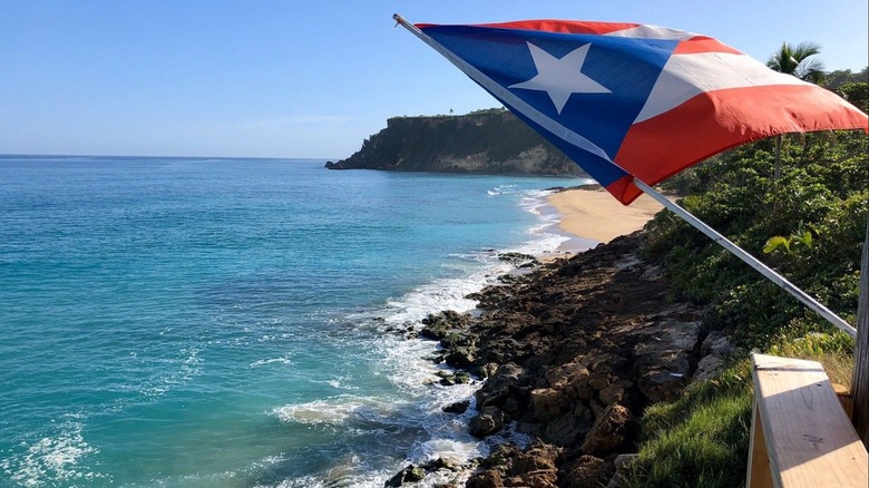 A beach in Aguadilla with the flag of Puerto Rico