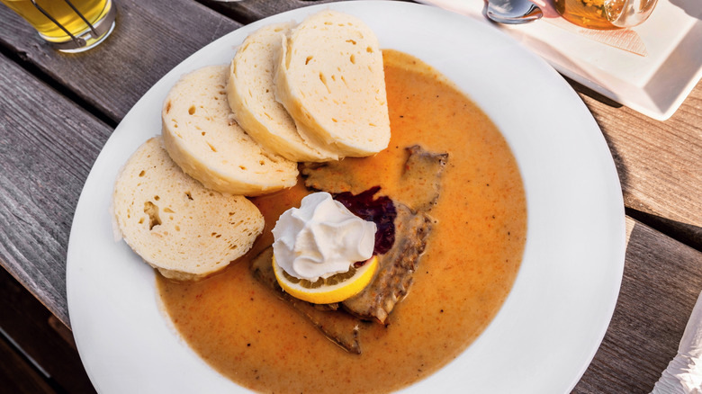 Plate of Svíčková (beef, bread dumplings, cranberries, and a slide of lemon) in Czechia