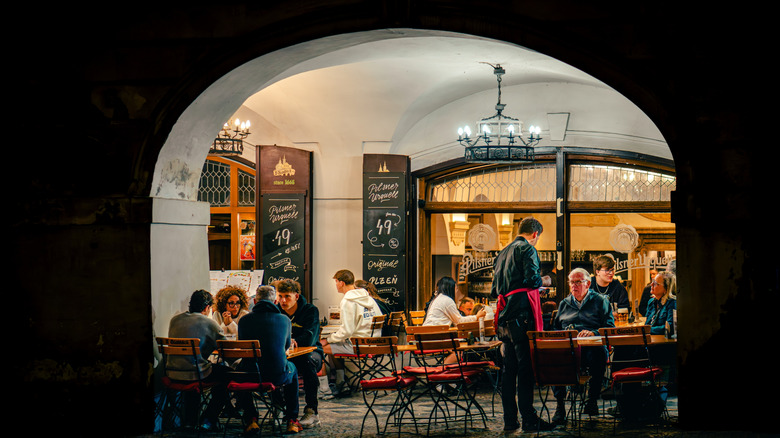 A busy outdoor restaurant in Prague, Czechia.