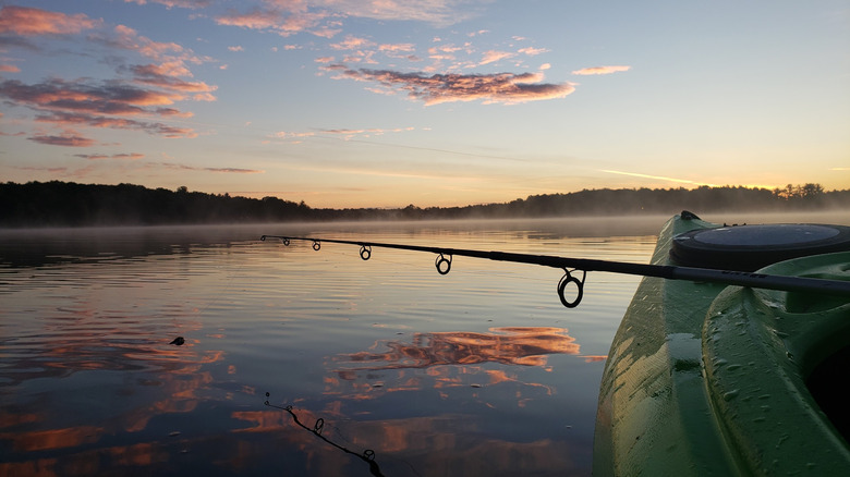 A kayaker fishing as the sun rises on Spider Lake in Grand Traverse County, Michigan