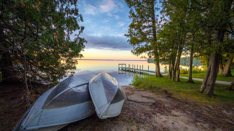 Rowboats on the beach with a wooden dock in the background at Indian Lake State Park, Michigan