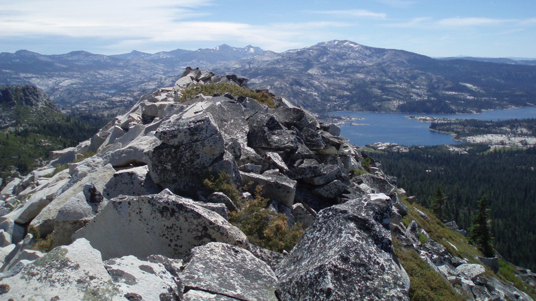 Distant view of Loon Lake through grey granite boulders and peaks