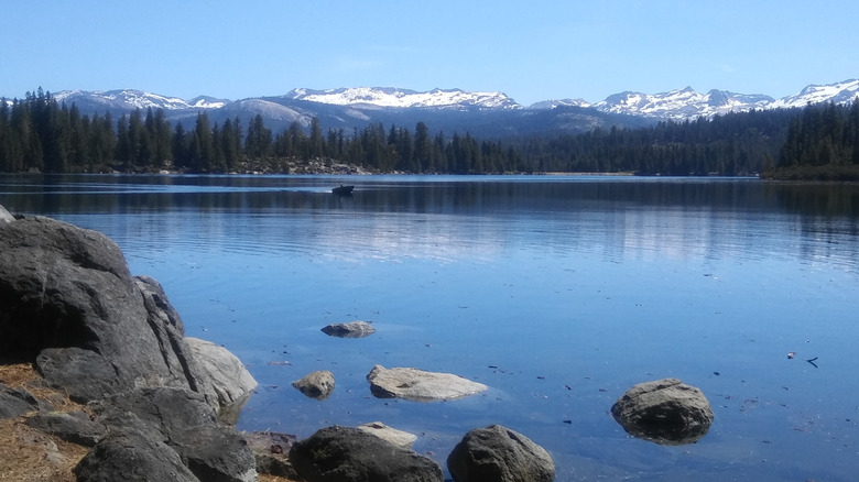 Loon Lake with snow-capped mountains in the background, blue skies overhead