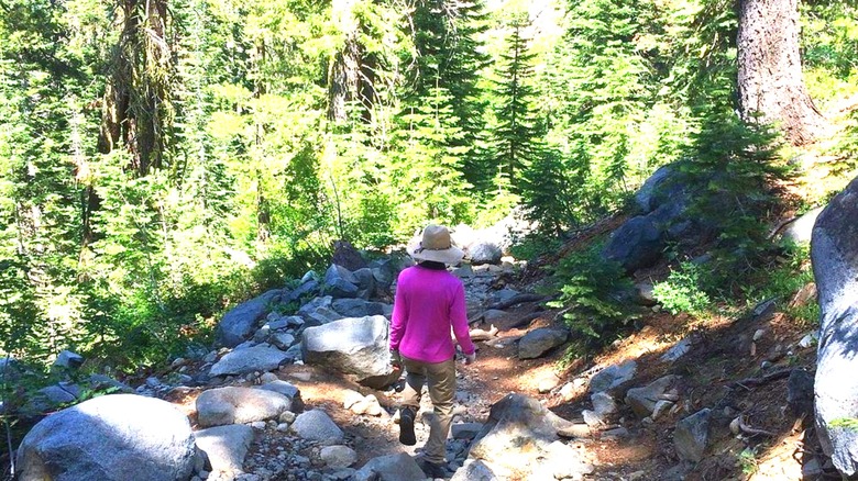 A woman hikes along the trail to Loch Leven Lakes