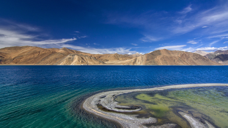 sections of the lake appear blue, dark green, grey, and light green in the sunlight