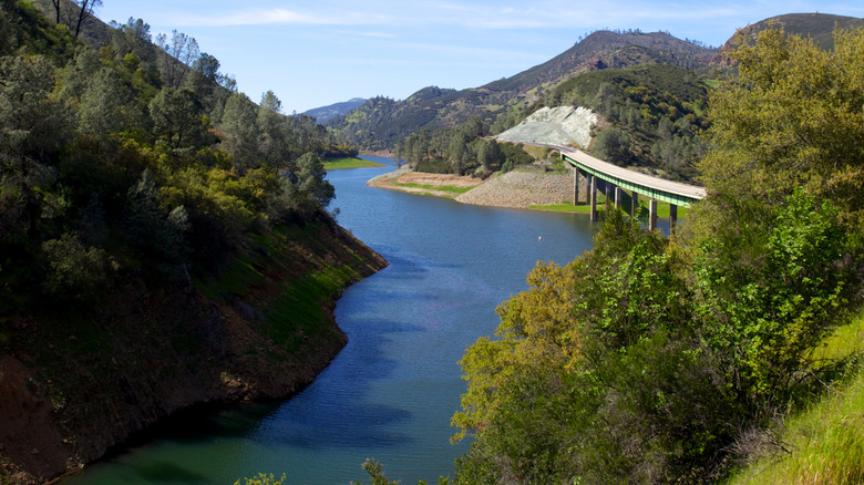 Road and bridge crossing Lake McClure, surrounded by rolling hills